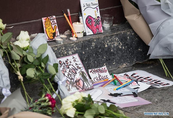 Flowers and cards are placed in front of the Le Petit Cambodge Restaurant where an attack happend the other day in Paris, France, Nov. 14, 2015. French President Francois Hollande announced a three-days national mourning on Saturday. (Photo: Xinhua/Xu Jinquan)