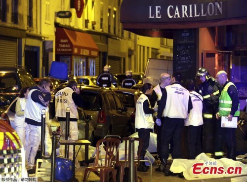 Rescue service personnel work near the covered bodies outside a restaurant following a shooting incident in Paris, France, November 13, 2015. Multiple, near-simultaneous attacks on entertainment sites rock Paris on Friday, leaving over 100 killed and scores taken hostage in a concert hall. (Photo/Agencies)