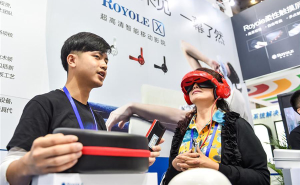 A visitor tries a 3,300 ppi portable cinema system in the 17th China Hi-tech Fair (CHTF) in Shenzhen, south China's Guangdong province, Nov 16, 2015. (Photo/Xinhua)
