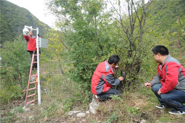 Staff members from Heihe National Forest Park install surveillance and infrared cameras in essential places to monitor the behavior of tourists as well as wild animals.(Photo by Xu Lin/China Daily)