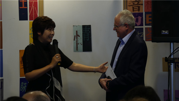 Yu Dan speaks to a French official during the event about learning Chinese characters at the headquarters of UNESCO in Paris in October. (Photo provided to China Daily)