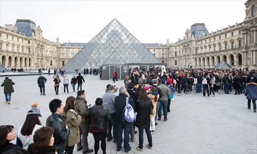 Tourists line up at the Louvre in Paris on Monday, days after the November 13 terrorist attacks in the city. (Photo/Xinhua)