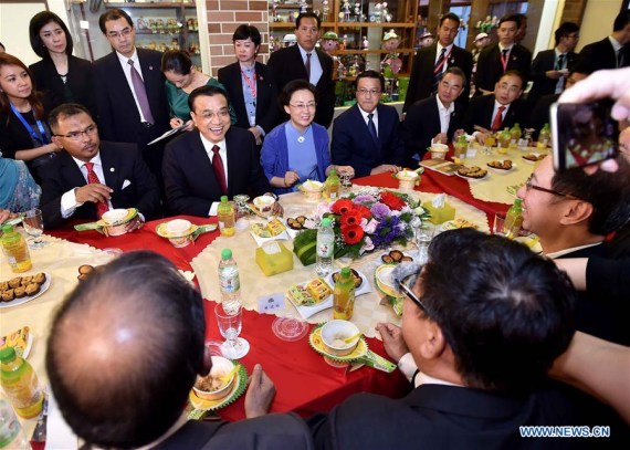 Chinese Premier Li Keqiang (2nd L, front) interacts with old friends and representatives of local people at San Shu Gong specialty shop in Malacca, Malaysia, Nov. 22, 2015. Li, accompanied by his wife Cheng Hong, visited Malacca on Sunday. (Photo; Xinhua/Li Tao)