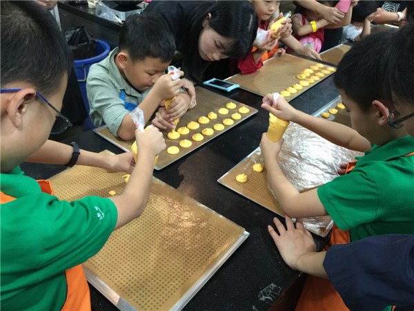 Primary-grade students from a Beijing language academy at Gateaux& Cadeaux for a lesson in making macaroons. (Photo by Mike Peters/China Daily)