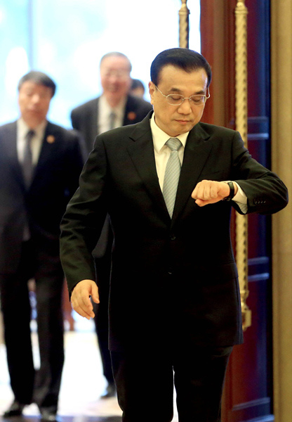 Chinese Premier Li Keqiang checks the time on his way to a series of diplomatic meetings in Suzhou on Nov 24, 2015, just hours after he wrapped up a busy trip to Malaysia for the ASEAN annual meeting. Chinese media dubbed Li's diligent working style "Keqiang rhythm". WU ZHIYI/CHINA DAILY