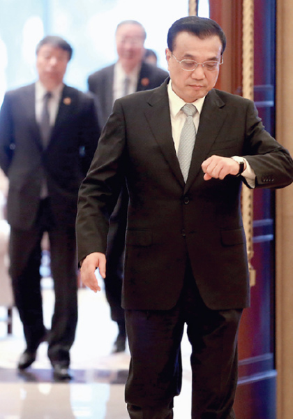Premier Li Keqiang checks the time on his way to a series of diplomatic meetings in Suzhou on Tuesday, just hours after he wrapped up a busy trip to Malaysia for the ASEAN annual meeting. Chinese media dubbed Li's diligent working style "Keqiang rhythm". (Photo by Wu Zhiyi/China Daily)