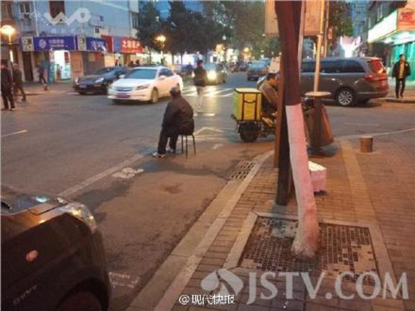 Zhou's husband also sits in the parking space. (Photo from Weibo)