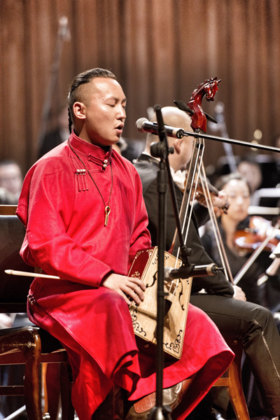 Unir sings while playing the morin khuur, or horse-head fiddle, during a performance. (Photo provided to China Daily)