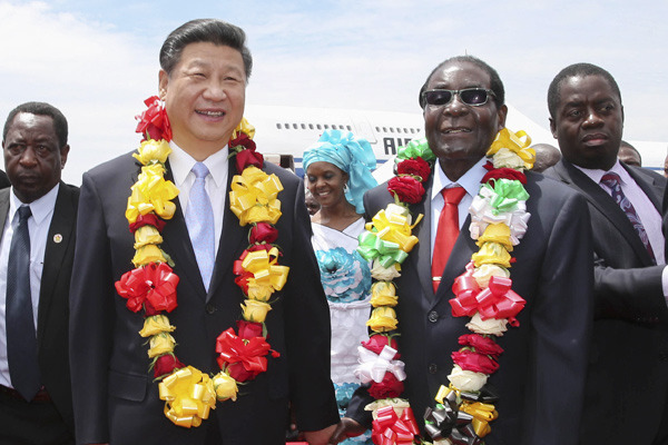 President Xi Jinping is welcomed by Zimbabwe's President Robert Mugabe upon his arrival in Harare on Tuesday. Xi called close ties with Zimbabwe a cornerstone of China's foreign policy.(Photo by Lan Hongguang/Xinhua)