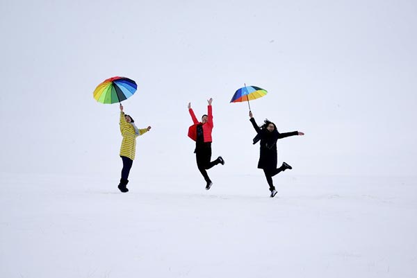 Tourists dance on snow in Inner Mongolia autonomous region on Nov 27. (Photo/Xinhua)