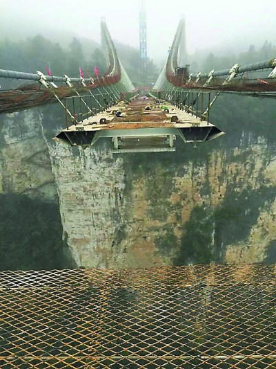 The skywalk glass bridge stretching across the Zhuangjiajie Grand Canyon will soon be completed. (Photo/Changjiang Daily)