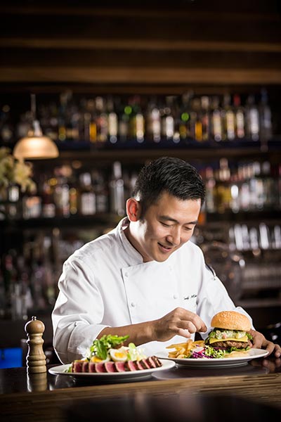Blue Frog chef with bbq burger and tuna salad. (Photo provided to China Daily)