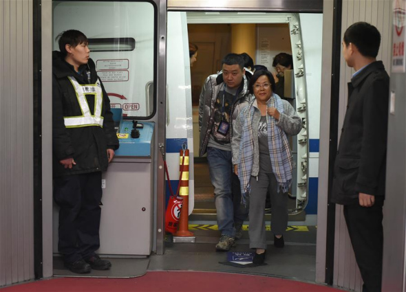 Huang Yurong, 64, one of the suspects from China's most wanted economic fugitives, arrives at Capital International Airport in Beijing, capital of China, Dec. 5, 2015, surrendering herself to the Chinese police after 13 years in the United States.(Photo: Xinhua/Zhou Zhe)