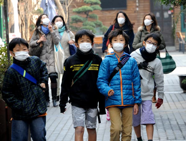 Pedestrians wear masks during a heavy smog day in Shanghai. (Photo/China Daily)