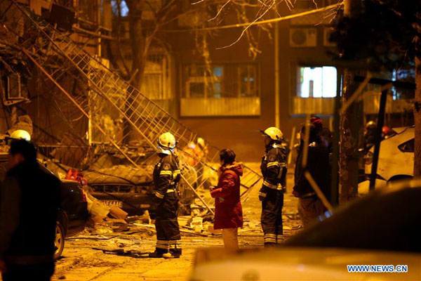 Rescue workers stand in front of the building where an explosion happened in the Yongle community of Shijingshan District in Beijing, capital of China, on Dec 7, 2015. No casualty was reported. (Photo/Xinhua)