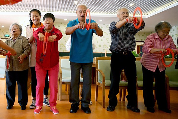 Senior citizens take exercises at a care home in Beijing. The number of beds at such institutions is far from sufficient in the capital. (Jiang Dong/China Daily)