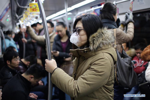 A passenger wears a mask as she takes a subway in Beijing, capital of China, Dec. 8, 2015. Beijing has issued its first red alert for air pollution under a four-tier emergency response system created in October 2013. (Photo: Xinhua/Jin Liwang)