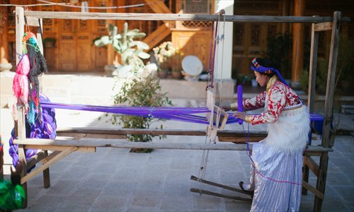 Shougong Geiru Yongqing weaves on a loom at her house. (Photo: Li Hao/GT)