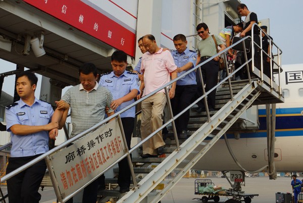 Two economic fugitives (second and fourth) are repatriated on Aug 3, 2014 from Cambodia after fleeing overseas with illicit assets. (Photo/China Daily)