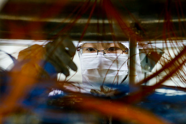 A scientist checks equipment designed for dark matter research at Jinping Underground Laboratory. SHEN BOHAN/XINHUA