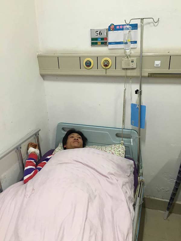 Cheng Yiquan, a cement factory worker, receives treatment at Guangming new district hospital after surviving a fatal landslide which hit his dormitory building Monday morning at the Liuxi Industrial Park in Guangming New District in Shenzhen city, South China's Guangdong province.(Photo by Chai Hua/chinadaily.com.cn)