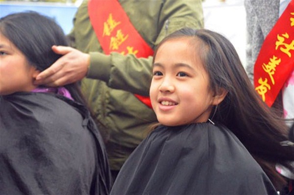 Students from Shanghai East Experimental School sit for a hair cut during a charity drive. The chopped hair are used to make wigs for cancer patients.(Ti Gong)