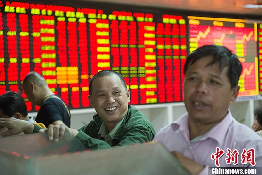 File photo of investors at an exchange in Haikou on December 3. (Photo/China News Service)