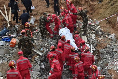 A trapped person is found dead at the site of landslide at an industrial park in Shenzhen, south China's Guangdong Province, Dec. 23, 2015. There was one survivor pulled out alive while the other found dead at the landslide site by far, but still 75 missing in the landslide. (Xinhua/Liang Xu)