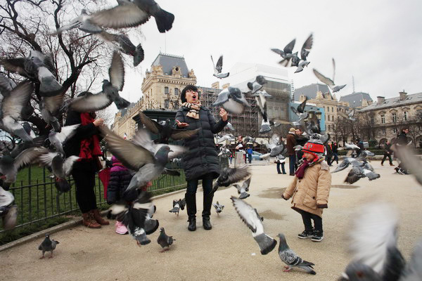 Chinese tourists play in front of Notre-Dame de Paris. Data suggest a record number of them chose to travel abroad during this year's Spring Festival. (Photo/China Daily)