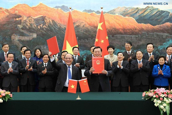 Zhang Dejiang (front, R), chairman of the Standing Committee of China's National People's Congress (NPC), and Chairman of Vietnamese National Assembly Nguyen Sinh Hung (front, L) jointly sign a cooperation agreement between China' NPC and Vietnamese National Assembly after their talks in Beijing, capital of China, Dec. 24, 2015. (Photo: Xinhua/Pang Xinglei)