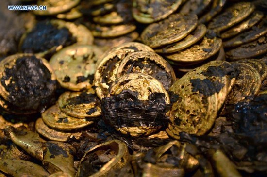 hoto taken on Dec. 24, 2015 shows gold cakes unearthed from the main coffin in the Haihunhou (Marquis of Haihun) cemetery, east China's Jiangxi Province. There were 96 gold cakes and several hoof-sahped golds newly unearthed between the inner and external coffin at the Haihunhou cemetery on Dec. 24, making the number of gold cakes unearthed here rise to 285, the most among all archaeological excavations of the Han Dynasty (206 B.C.-220 A.D.) tombs. (Photo: Xinhua/Wan Xiang)