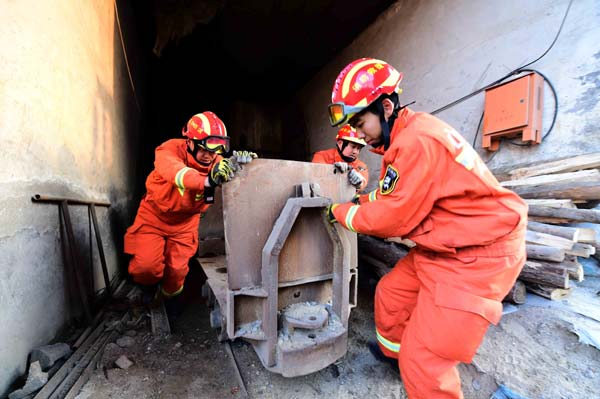 Rescuers clear the pithead of the collapsed mine in Pingyi County, east China's Shandong Province, Dec. 26, 2015. Eleven of the 29 people trapped on Friday in the collapsed gypsum mine have been rescued by Saturday morning, rescuers said. A total of 29 people were working underground when the collapse occurred at about 8 a.m. Friday. Ten of them were rescued on the same day. Rescuers have located the 18 miners who are trapped at two different sites. (Xinhua/Guo Xulei)