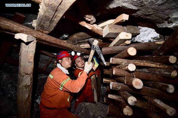 Rescuers work under 300 meters in the collapsed mine in Pingyi County, East China's Shandong Province, Dec 27, 2015. Eleven of the 29 people trapped on Friday in the collapsed gypsum mine have been rescued by Saturday morning. One died and 17 people are still trapped by Sunday. (Photo/Xinhua)