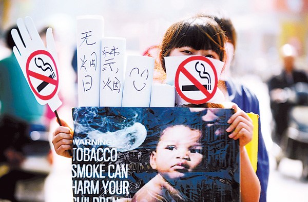 A student from Yangzhou University demonstrates against smoking during a street campaign in Yangzhou, Jiangsu province, on Sunday. (Photo: China Daily/Meng Delong)