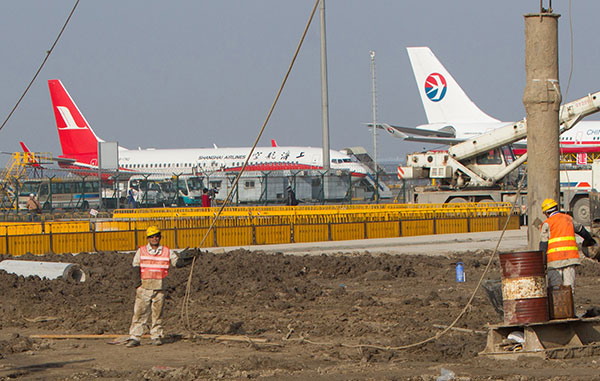 Workers are busy with the expansion project of Shanghai Pudong International Airport on Tuesday. (Photo: China Daily/Gao Erqiang)