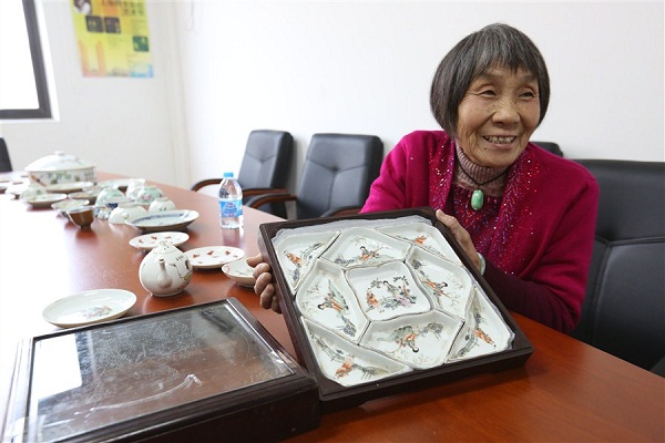 A senior local Yang Jinmei shows the media her china collection. It would be among those provided by local citizens to be put on display at the annual exhibition of Spring Festival customs, folk culture and arts will run from January 30 to February 29 at the Shanghai Mass Art Center.(Wang Rongjiang)