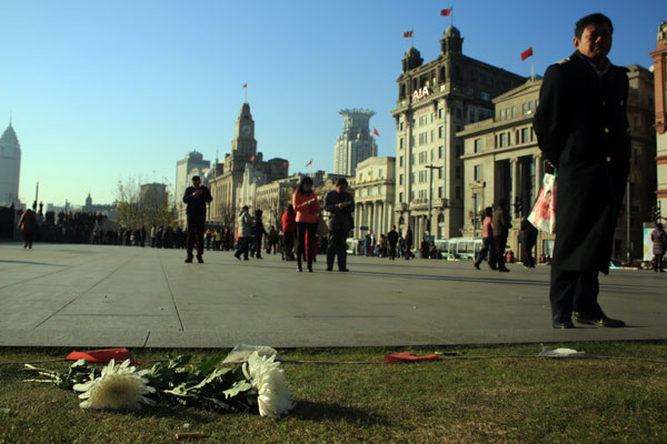 Flowers are placed on the ground to mourn the victims killed in a stampede in downtown Shanghai January 1, 2015. New Year's revelers crowded the Shanghai's Bund area around midnight on New Year's Eve when the tragedy occurred in Chenyi Square. At least 36 people were killed. (Photo: China Daily/Ren Guoqiang)