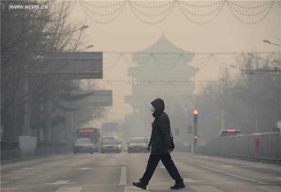 A pedestrian walks amid heavy smog in Beijing, capital of China, Dec 29, 2015. (Photo/Xinhua)