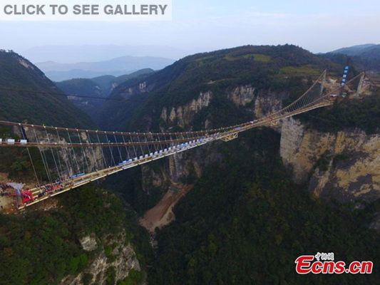 Steel decks of a skywalk glass bridge are joined in Zhangjiajie, Central China's Hunan province on Thursday morning, December 3, 2015. Stretching across the Zhuangjiajie Grand Canyon, the glass bridge has set many world records. (Photo/CFP)