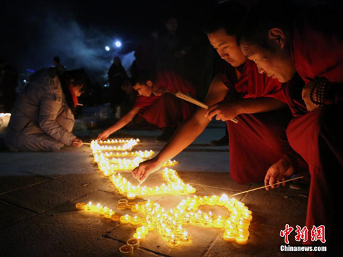 A Tibetan lama lights up lamps