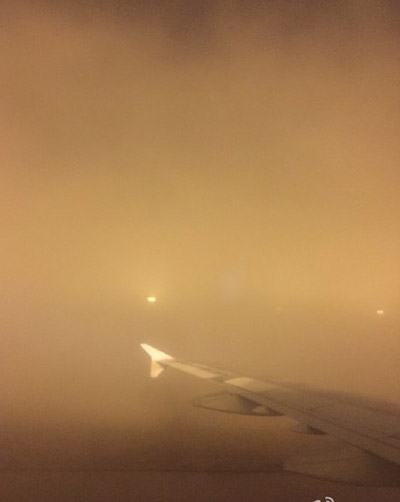This picture taken by a passenger inside an airplane at the Beijing International Airport shows haze outside. Photo/Weibo