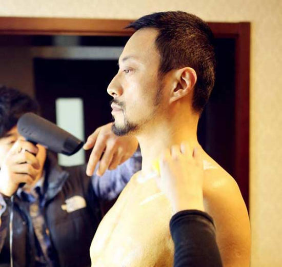 Special effects artists are pasting fake muscles on the chest of award-winning actor Zhang Hanyu so as to help him play the supporting role of Men Saner in Mr. Six. (Photo/Weibo)
