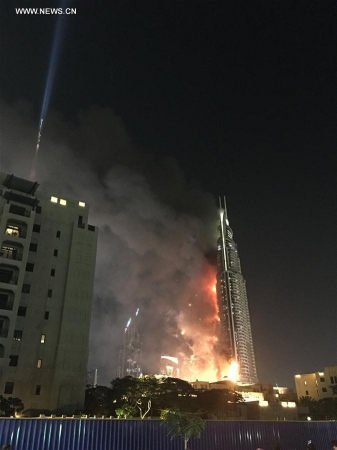 Photo taken by a mobile device shows Address Downtown Dubai hotel on fire in Dubai, the United Arab Emirates, on Dec. 31, 2015. Fire broke out on Thursday in a luxurious hotel in Dubai where people were gathering nearby to watch the New Year's fireworks show. (Xinhua/Liu Yang)