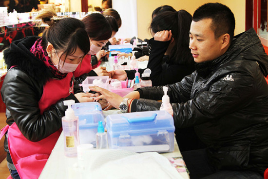A man gets amanicure at a beauty shop in Xuchang, Henan province. (Photo/China Daily)