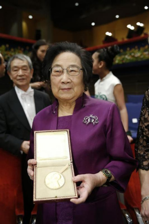 2015's Nobel laureate in Physiology or Medicine Tu Youyou (L) shows her medal following the Nobel Prize award ceremony at the Concert Hall in Stockholm, capital of Sweden, Dec. 10, 2015. (Photo: Xinhua/Ye Pingfan)
