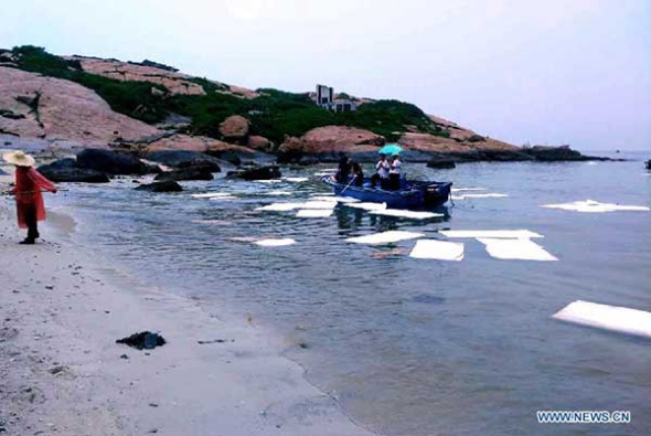 Decontamination team try to clean up the sea which is polluted by heavy oil on the Miaowan Island in Zhuhai, South China's Guangdong province, Aug 26, 2015.(Photo/Xinhua)
