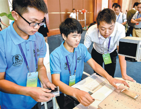 Students from a vocational school operate numerical control equipment at an exhibition that features educational exchanges between China and ASEAN member countries in Guiyang, Guizhou province, in August, 2015. (Photo/Xinhua)