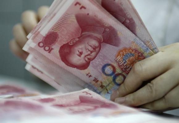 An employee counts yuan banknotes at a bank in Huaibei, Anhui province June 22, 2010.(Photo/Agencies)