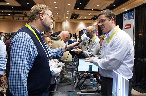A reporter interviews an employee from Lenovo Group Ltd at the Consumer Electronics Show in Las Vegas, the United States. Lenovo executives said the company will abandon the iconic Motorola name for its premium handset division.(Photo/Xinhua)