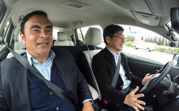 Chairman and CEO of Renault-Nissan Alliance Carlos Ghosn (left) takes the passenger seat in an autonomous car while Tetsuya Ijima, in charge of developing advanced driver assistance systems for Nissan Motor, relinquishes control of the vehicle. (Photo/China Daily)